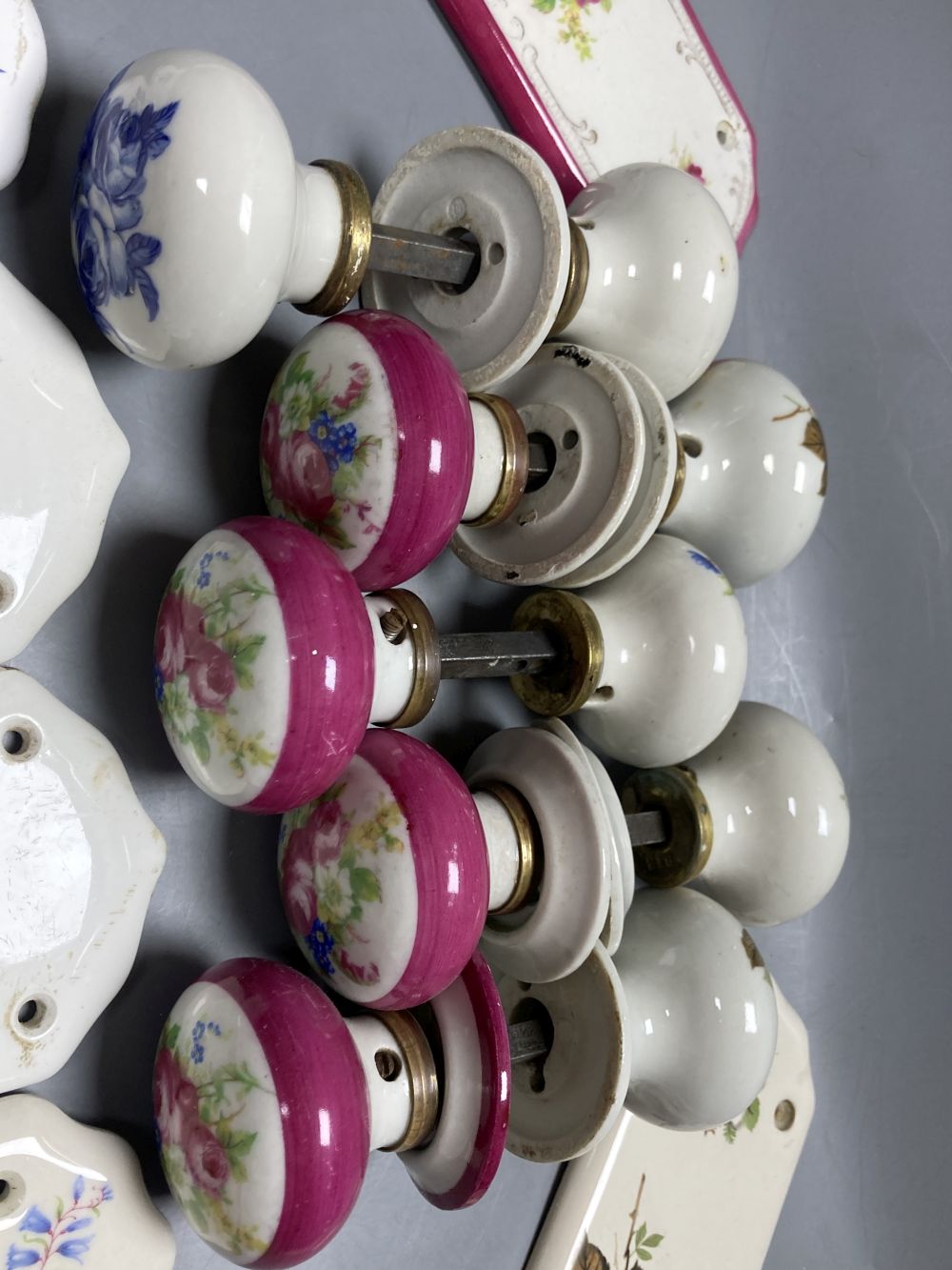Five pairs of French porcelain door handles and ten porcelain door plates